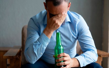 Мужчина держит бутылку